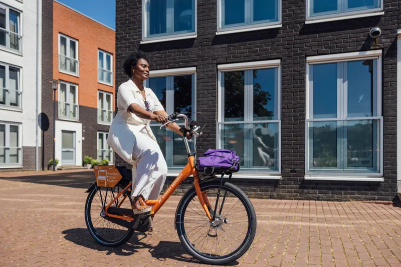 Vrouw op een deelfiets van Donkey Republic