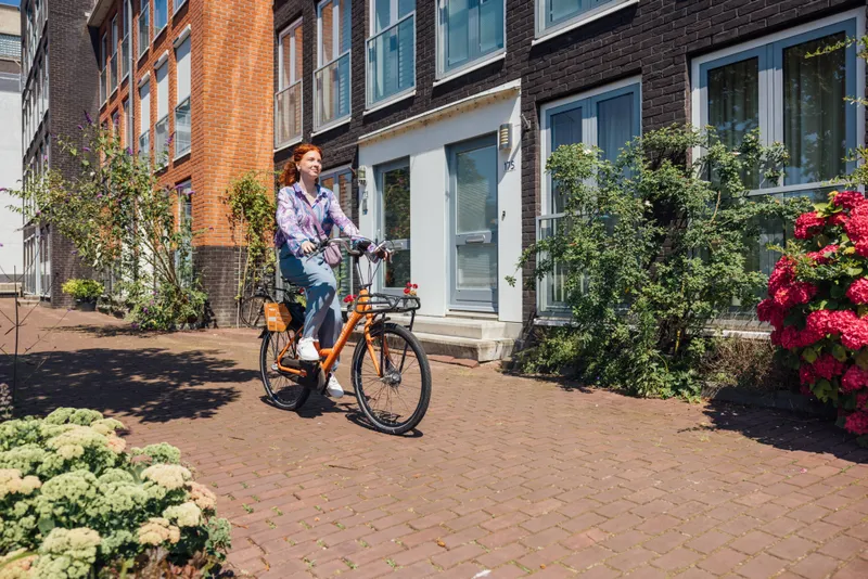 Vrouw op een deelfiets van Donkey Republic