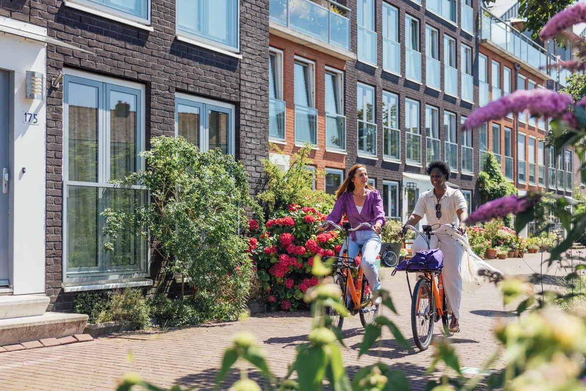 Twee vrouwen fietsen beiden op een deelfiets van Donkey Republic