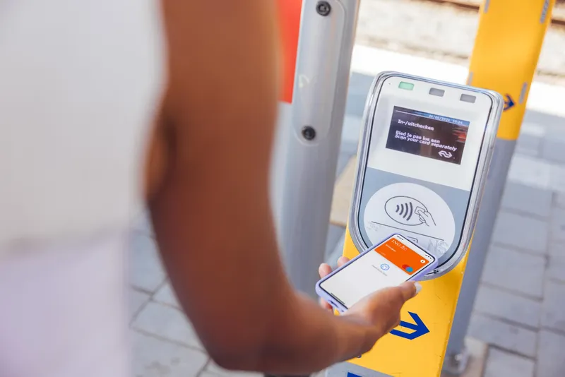 vrouw checkt in bij de trein met OVpay via haar mobiel.