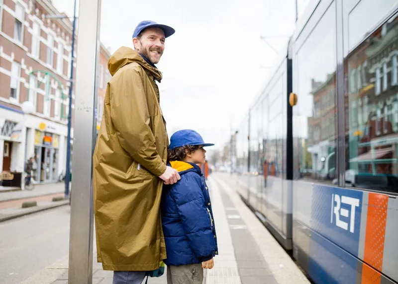 Vader en kind wachten op de tram